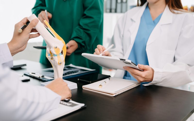 Medical technology network team meeting concept. Doctor hand working with smart phone modern digital tablet and laptop computer with graphics chart interface, with virtual icon diagram